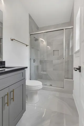 a bathroom with a shower a toilet and a sink