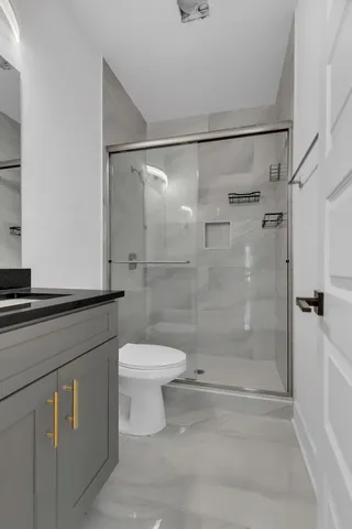 a bathroom with a shower a toilet and a sink