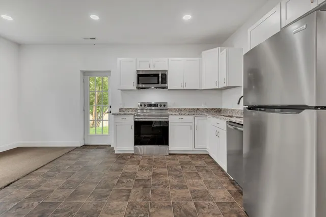 a kitchen with stainless steel appliances granite countertop a refrigerator sink and stove