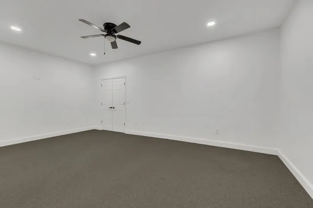 an empty room with a ceiling fan and window