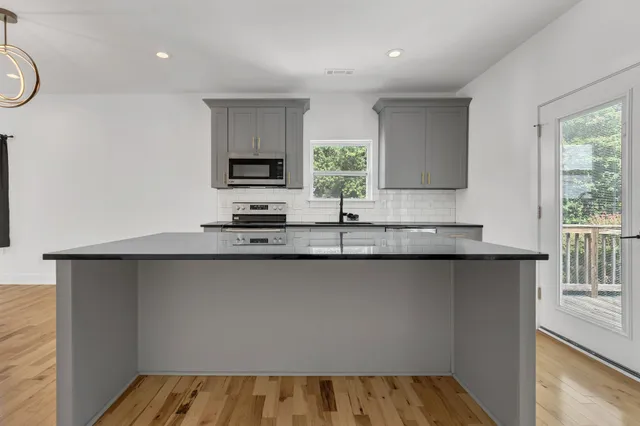 a kitchen with granite countertop a sink and a stove top oven