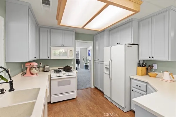 a kitchen with a refrigerator sink and white cabinets