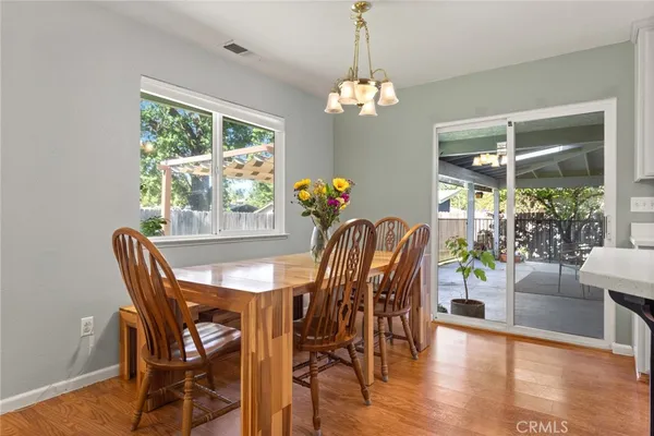 a dining room with furniture a large window and wooden floor