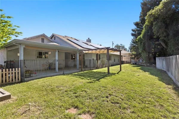 a view of a house with a small yard and wooden fence
