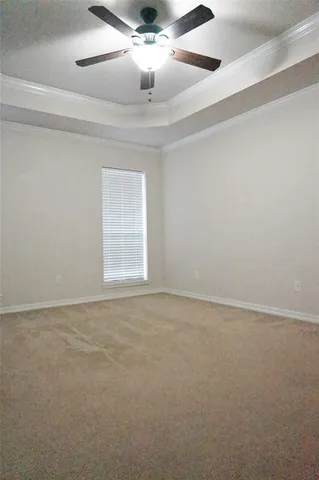 a view of an empty room and chandelier fan