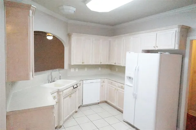 a kitchen with white cabinets and white appliances
