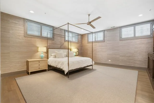 a bedroom with a large bed and wooden floor