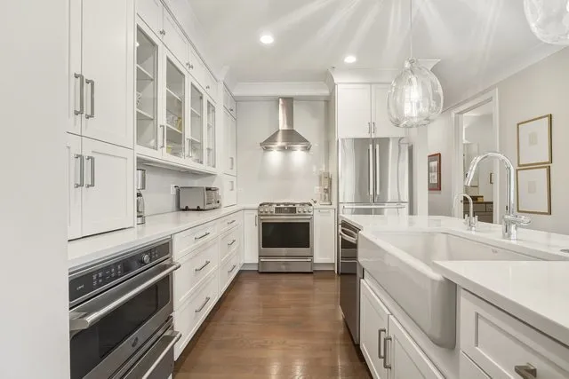 a large white kitchen with a large window