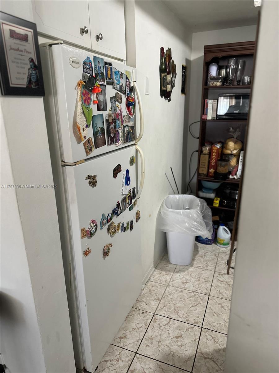 1400 Northeast 169th Street, Unit 215 Miami, FL 33162 - Photo 4 of 13 a white refrigerator freezer sitting inside of a kitchen