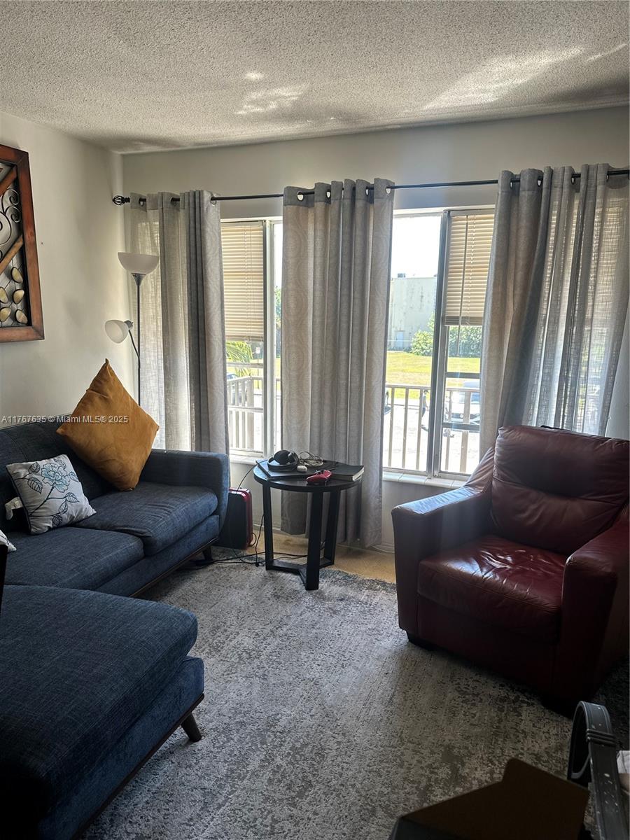 1400 Northeast 169th Street, Unit 215 Miami, FL 33162 - Photo 5 of 13 a living room with furniture and a window
