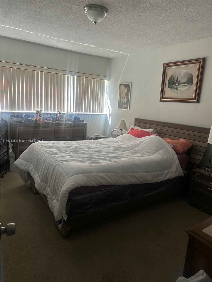 1400 Northeast 169th Street, Unit 215 Miami, FL 33162 - Photo 8 of 13 a bedroom with a bed wooden floor and window