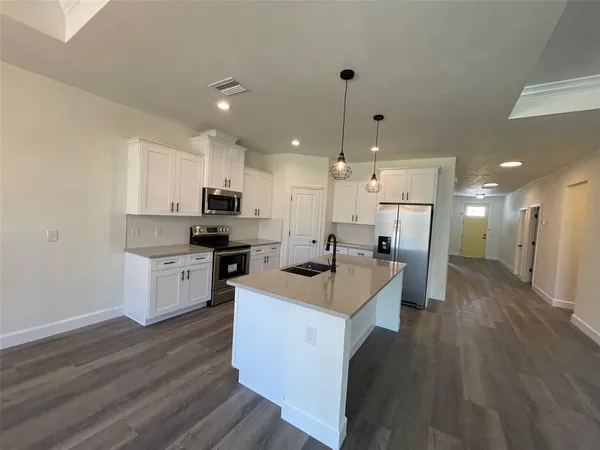 a kitchen with a sink a counter top space and stainless steel appliances