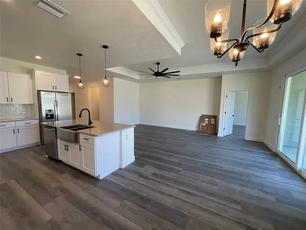 a kitchen with stainless steel appliances kitchen island wooden floors granite counter tops and wooden floors