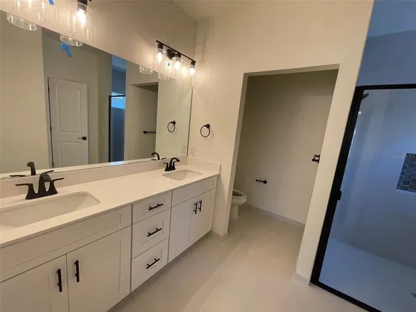 a spacious bathroom with 2 sink and a mirror
