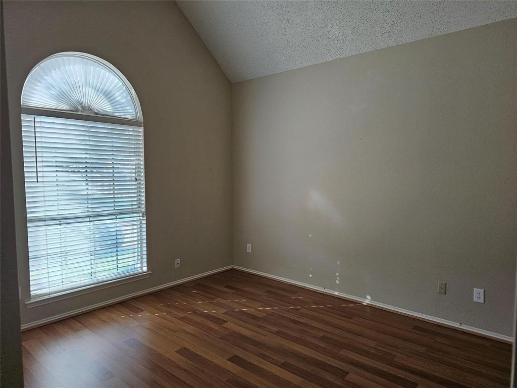 8400 Hickory Street, Unit 4501 Frisco, TX 75034 - Photo 11 of 15 Unfurnished room featuring vaulted ceiling, dark wood finished floors, and a textured ceiling