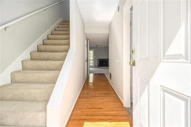 a view of a hallway with wooden floor and stairs
