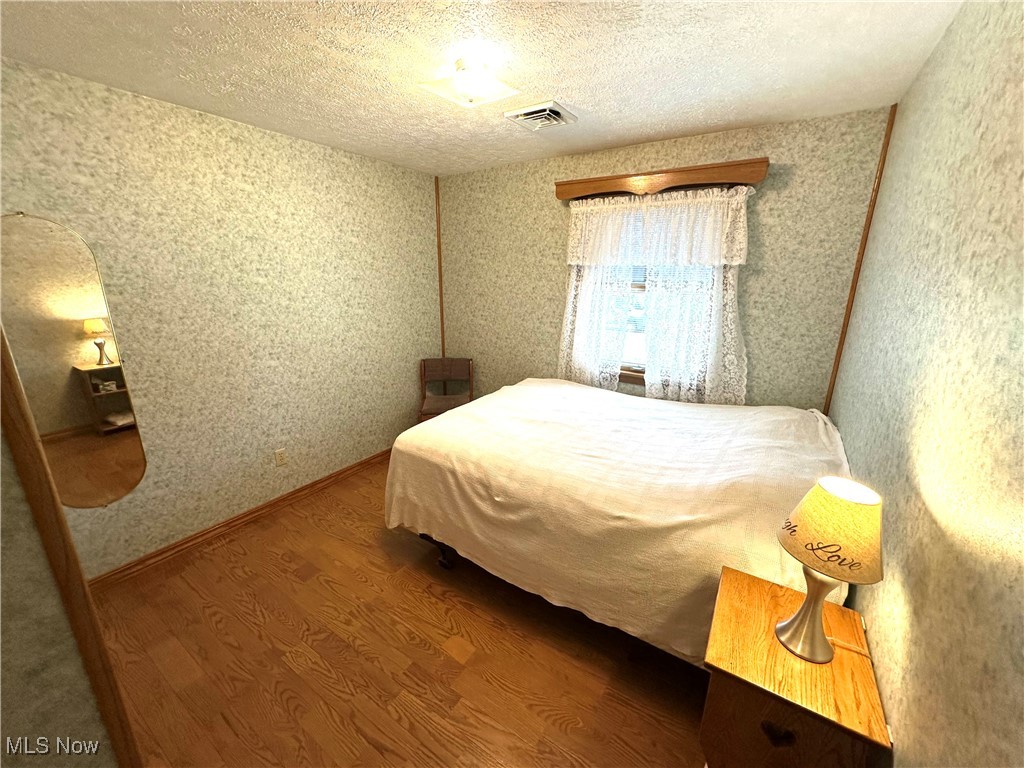 1684 Morris Street Mineral Ridge, OH 44440 - Photo 40 of 50 Bedroom with wood finished floors and a textured ceiling