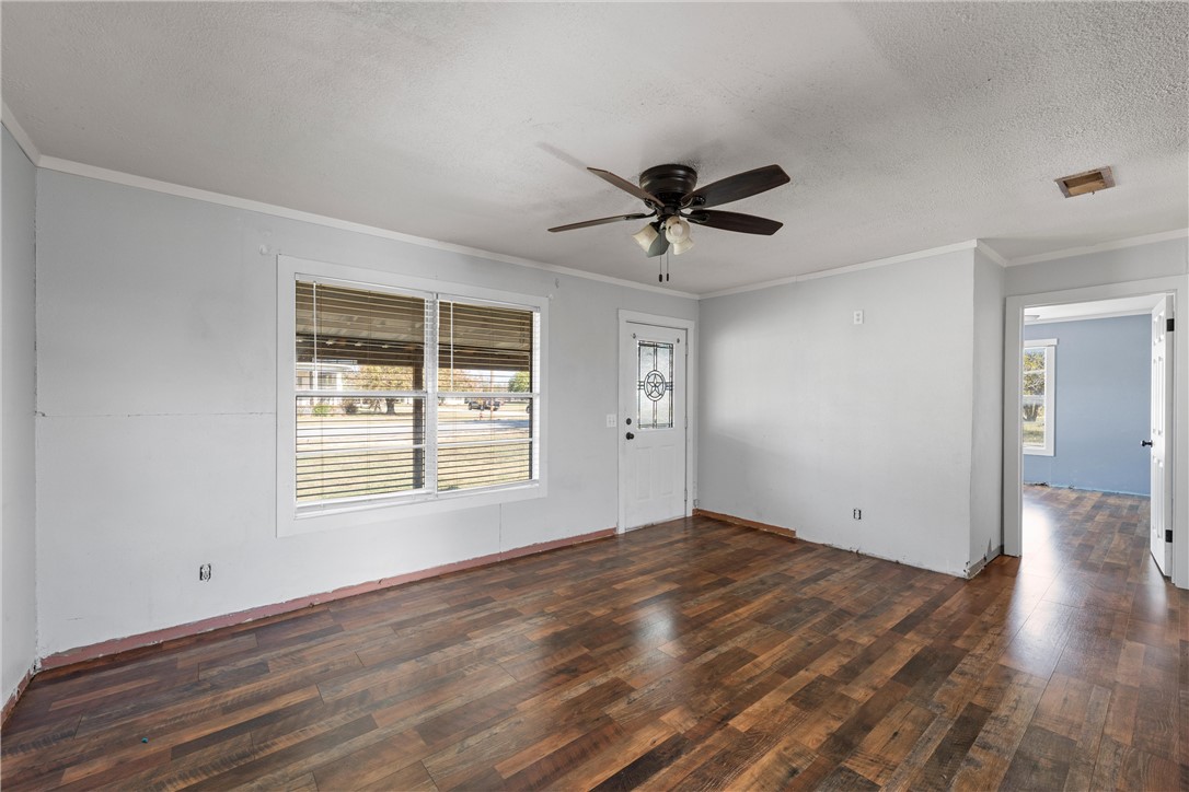 117 South Judge R W Hailey Drive Lott, TX 76656 - Photo 11 of 16 a view of an empty room with wooden floor and a window