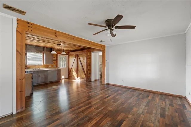 a view of empty room with wooden floor and windows
