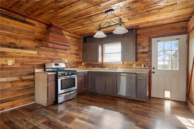 a kitchen with stainless steel appliances kitchen island granite countertop a stove a sink and a microwave