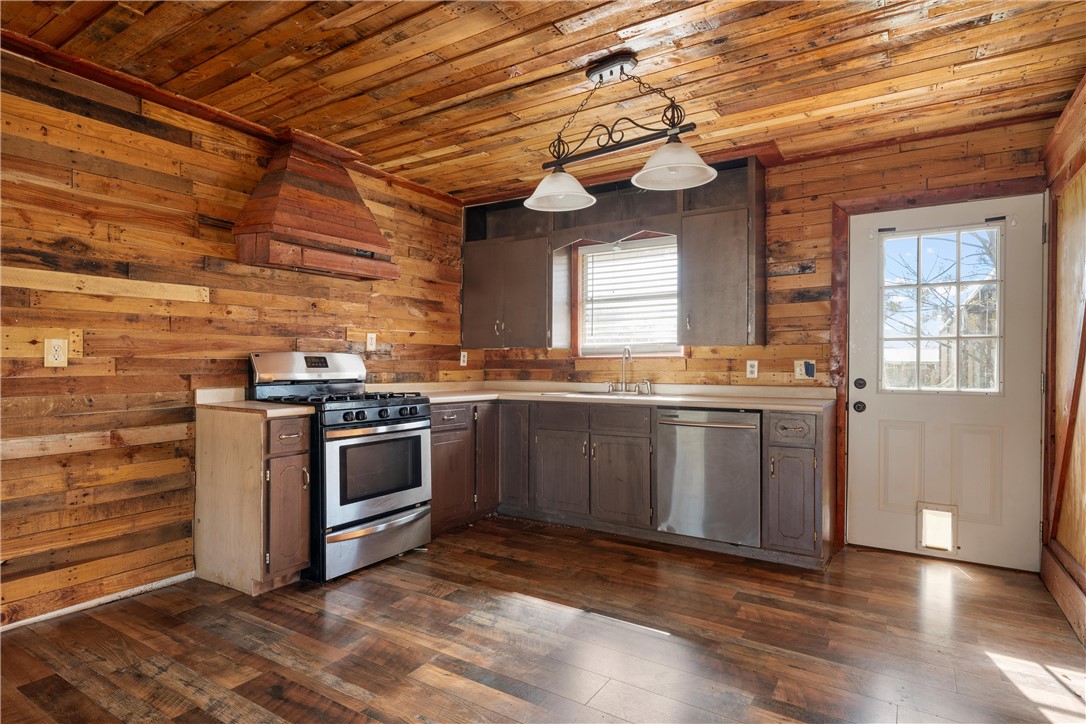 117 South Judge R W Hailey Drive Lott, TX 76656 - Photo 3 of 16 a kitchen with stainless steel appliances kitchen island granite countertop a stove a sink and a microwave