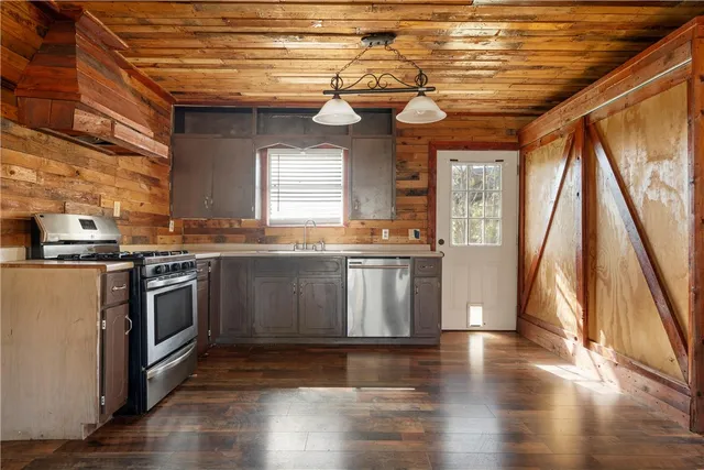 a kitchen with granite countertop wooden floors and stainless steel appliances