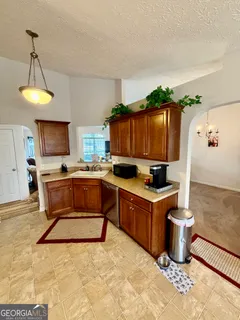 a kitchen with a stove a sink and a wooden cabinets