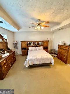 a bedroom with a bed and dresser with mirror