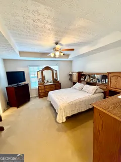 a bedroom with a bed and dresser with mirror