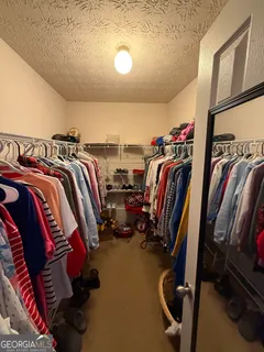 a view of walk in closet with clothes and shoes