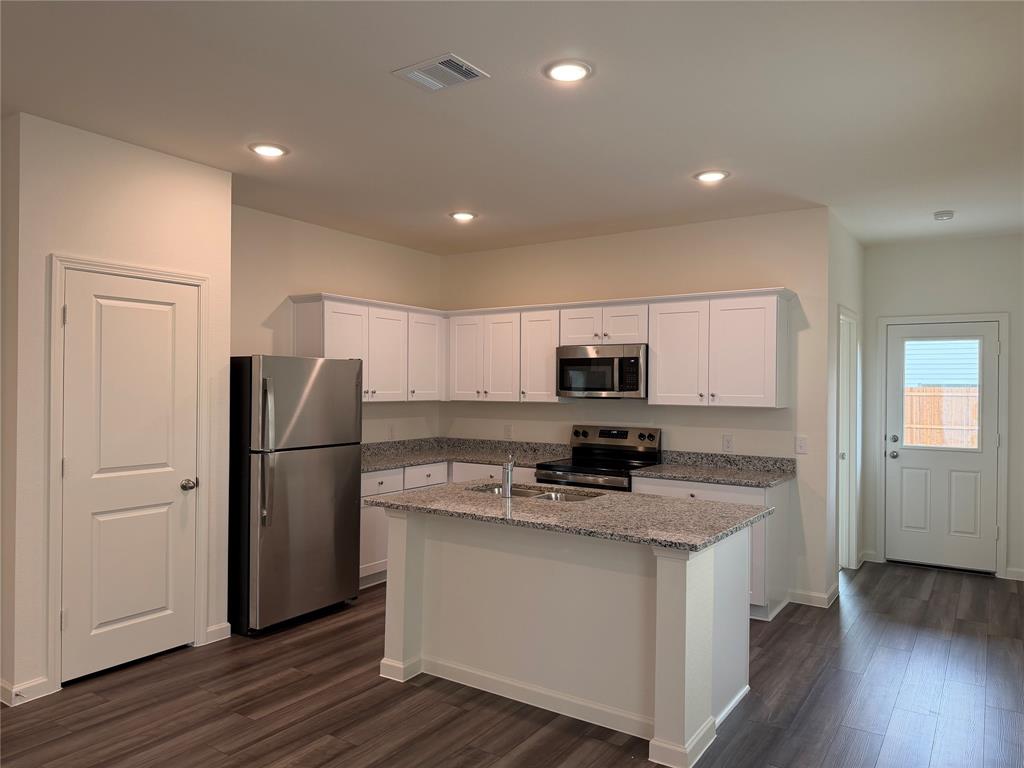 609 Merced River Lane Anna, TX 75409 - Photo 6 of 27 a kitchen with stainless steel appliances granite countertop a refrigerator a stove a sink and a microwave