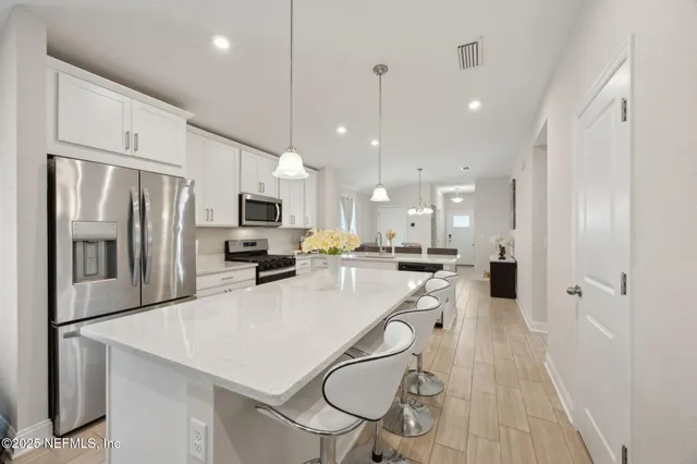 a kitchen with stainless steel appliances a refrigerator sink and microwave