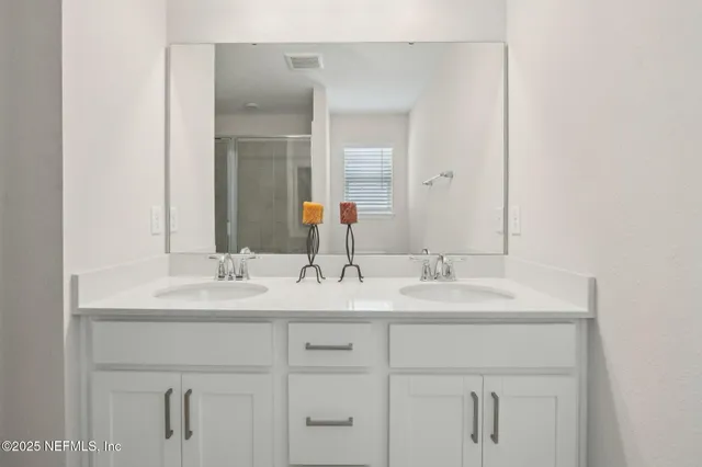 a bathroom with double sink and a mirror
