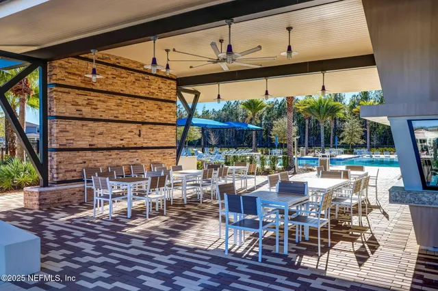 a outdoor space with lots of tables a chair and a potted plant