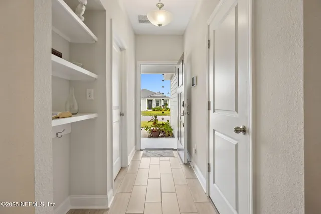 a view of a hallway with wooden shelves