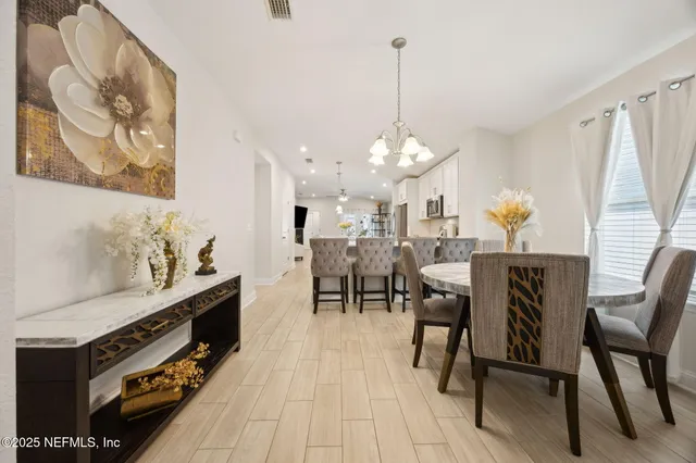 a view of a dining room with furniture and chandelier