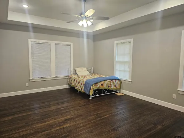 a bed sitting in a bedroom next to a window and a chandelier