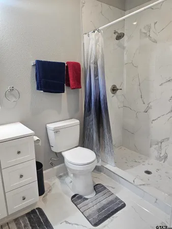 a bathroom with a toilet and a shower