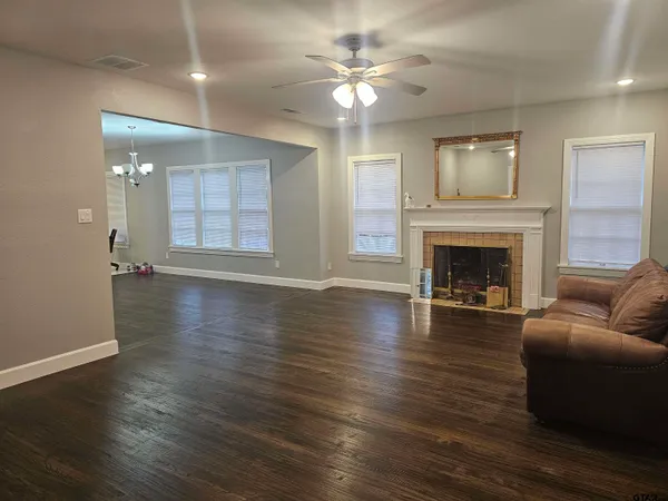wooden floor fireplace and windows in an empty room