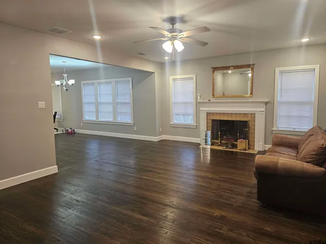 wooden floor fireplace and windows in an empty room