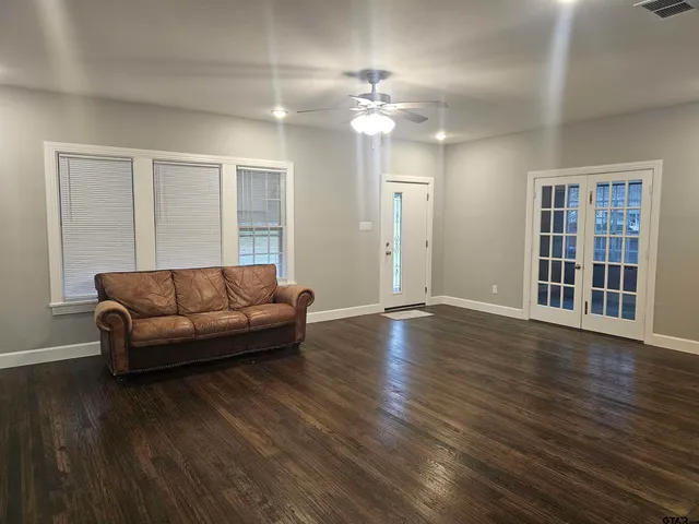 a living room with furniture and a wooden floor