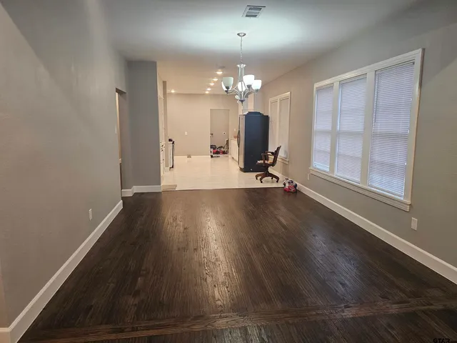 a view of a room with wooden floor and a large window