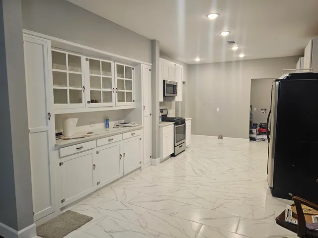 a large white kitchen with cabinets
