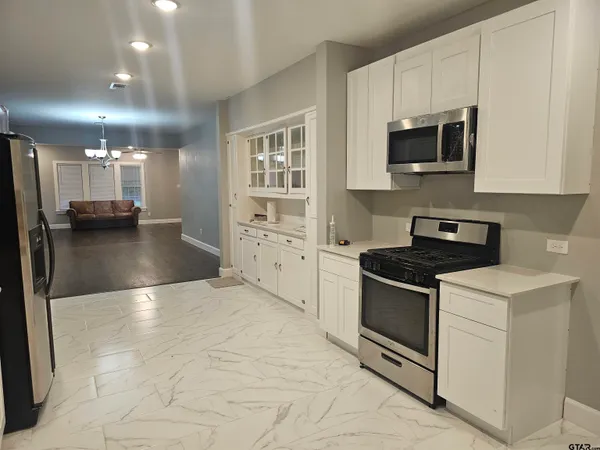 a kitchen with stainless steel appliances granite countertop a stove a sink and a microwave