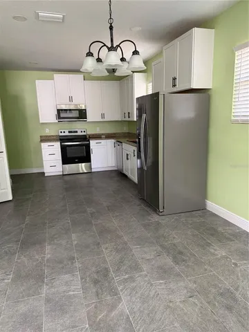 a kitchen with stainless steel appliances granite countertop a sink a stove a refrigerator and cabinets