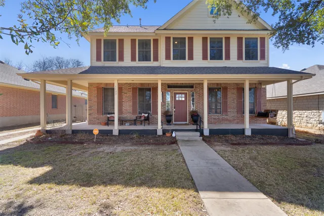 a view of a brick house with many windows next to a road