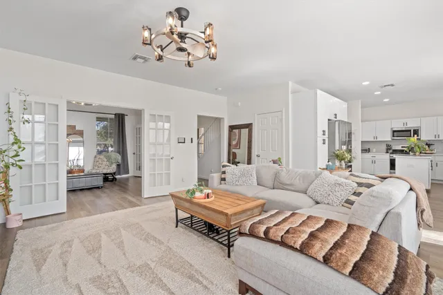 a living room with furniture and a chandelier