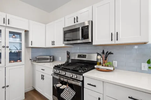 a kitchen with stainless steel appliances a stove a microwave and cabinets