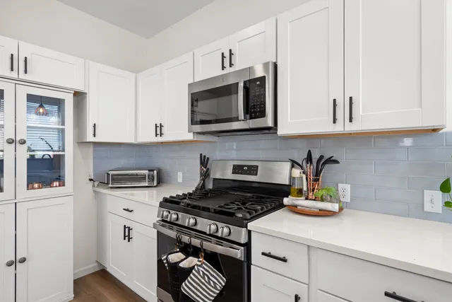 a kitchen with stainless steel appliances a stove a microwave and cabinets