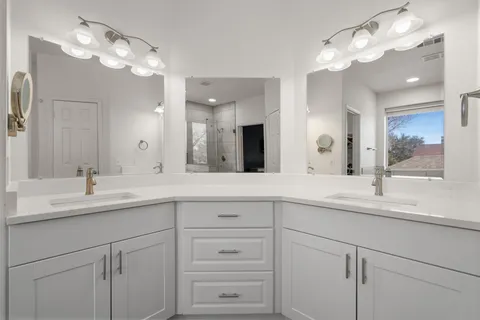 a spacious bathroom with a granite countertop sink a mirror and shower